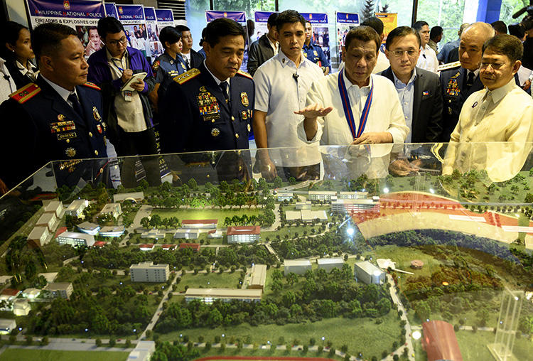 Philippine President Rodrigo Duterte (C) gestures as he looks at the diorama of the new Philippine National Police Academy during the 118th anniversary of the service, at the Camp Crame headquarters in Manila on August 9, 2019. A radio journalist was killed in the central Philippines on November 7, 2019. (AFP/Noel Celis)