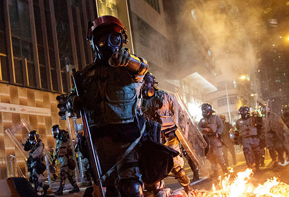 Police in riot gear pass a burning barricade in Hong Kong on November 2, 2019. Journalists covering the unrest are at risk of injury as police and protesters clash. (Reuters/Thomas Peter)