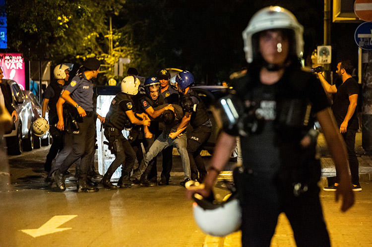 A man films as police detain a protester during a demonstration in Istanbul against the replacement of Kurdish mayors with state officials in three cities, on August 20. CPJ spoke with six journalists about the challenges of reporting and covering news in Turkey. (AFP/Yasin Akgul)