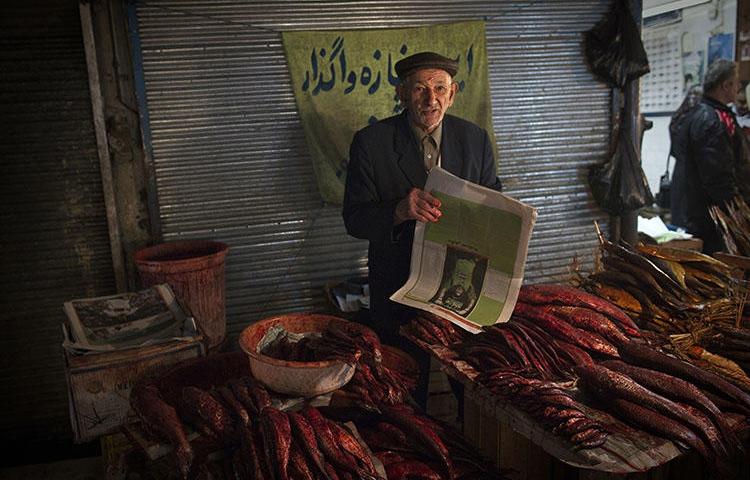 A fishmonger pictured at a bazaar in the Iranian city of Rasht, in March 2011. In 2018, Turkey extradited a journalist from Rasht whom authorities later sentenced to 10 years in prison for his work. (AFP/Behrouz Mehri)