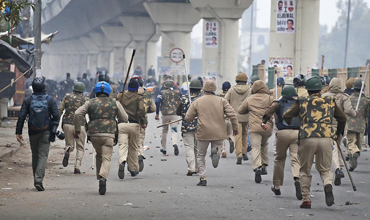 Police officers chase protesters in New Delhi, India, on December 17, 2019. Several journalists have been attacked since the protests began. (AP/Manish Swarup)