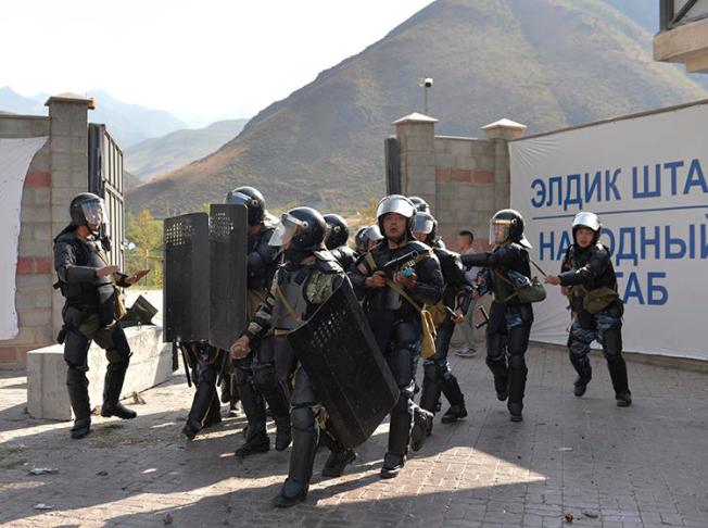 Police officers are seen in Koi-Tash, Kyrgyzstan, on August 8, 2019. CPJ recently joined a letter urging the Kyrgyz government to stop harassing journalists. (AP/Vladimir Voronin)