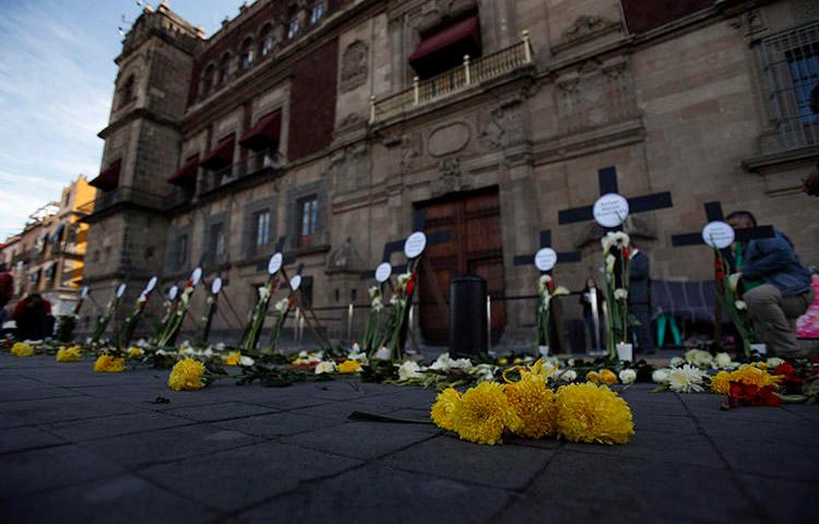 Flores y cruces llevan el nombre de periodistas y personas defensoras de los derechos humanos asesinados en los primeros tres meses de la gestión del presidente Andrés Manuel López Obrador, en febrero de 2019 en Ciudad de México. Como mínimo, dos de los periodistas que fueron asesinados por su labor en 2019, se habían incorporado a un mecanismo de protección. (AP/Rebecca Blackwell)