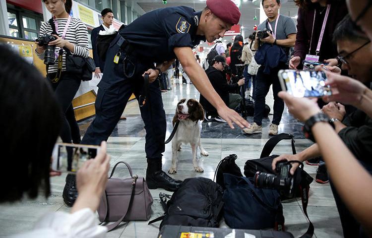 A security officer checks journalists' belongings at Macau International Airport on December 18, 2019. At least three journalists were recently denied entry into the territory. (Reuters/Jason Lee)