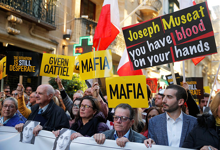 1 Aralık 2019 günü, Malta'nın başkenti Valetta'da protestocular gazeteci Daphne Caruana Galzia cinayeti için adalet isteyen bir eylemde pankartlarla görülüyor. (Reuters/Vincent Kessler)