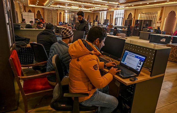 Kashmiri students use the internet at a Tourist Reception Centre in Srinagar on December 3, 2019, amid an internet suspension across the region as part of a partial communication blockade by the Indian government. Despite a Supreme Court ruling in January 2020, internet access has only been partially restored, and many news outlets remain offline. (AFP/Tauseef Mustafa)