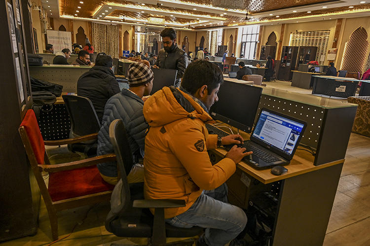 Kashmiri students use the internet at a Tourist Reception Centre in Srinagar on December 3, 2019, amid an internet suspension across the region as part of a partial communication blockade by the Indian government. Despite a Supreme Court ruling in January 2020, internet access has only been partially restored, and many news outlets remain offline. (AFP/Tauseef Mustafa)