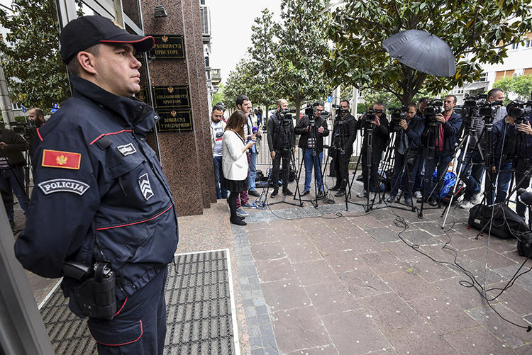 Journalists and law enforcement are seen in Podgorica, Montenegro, on May 9, 2019. Montenegro authorities recently arrested journalist Anđela Đikanović and charged her with incitement. (AFP/Savo Prelevic)