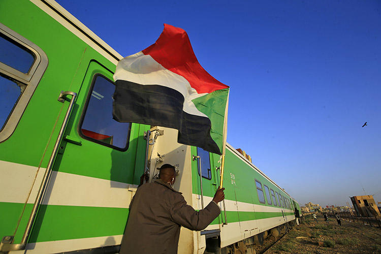 Sudanese protesters wait at a railway station in Khartoum on December 19, 2019 ahead of celebrations of the one-year anniversary of a protest movement that ousted the president. The transitional government in January suspended four news outlets over alleged links to the previous regime. (AFP/Ashraf Shazly)