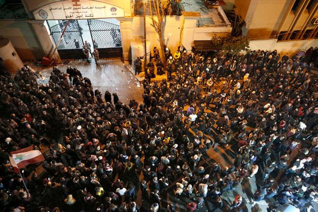 Protesters and police officers are seen in Beirut, Lebanon, on January 15, 2020. Police attacked and detained journalists covering the recent protests in Beirut. (AP/Hussein Malla)