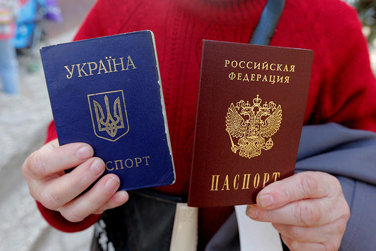 A woman poses with a Ukrainian and a Russian passport in the Crimean city of Simferopol on April 7, 2014. Ukrainian journalist Taras Ibragimov was recently barred from entering Crimea and was banned from entering Russia for 34 years. (Reuters/Maxim Shemetov)