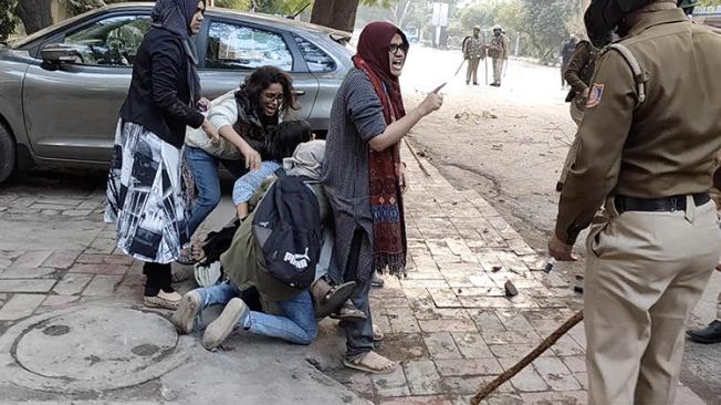 Women form a human shield to protect Shaheen Abdulla, a journalist with news website Maktoob Media, from police wielding batons at Jamia Millia Islamia University in New Delhi, India, on December 15, 2019. Journalists have been attacked in cities across India while covering recent protests. (Ghulam Hussain via Reuters)