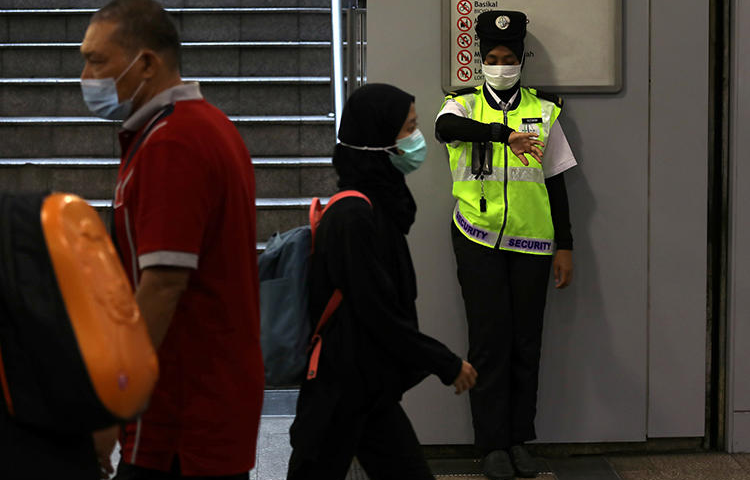 A security guard is seen in Kuala Lumpur, Malaysia, on January 31, 2020. Malaysian authorities recently filed criminal charges against journalist Wan Noor Hayati Wan Alias. (Reuters/Lim Huey Teng)