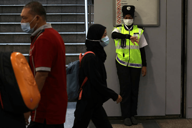 A security guard is seen in Kuala Lumpur, Malaysia, on January 31, 2020. Malaysian authorities recently filed criminal charges against journalist Wan Noor Hayati Wan Alias. (Reuters/Lim Huey Teng)