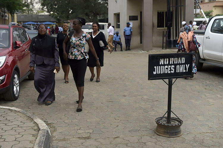 People walk at the premises of Lagos State High Court on January 29, 2019. Nigerian journalist Fejiro Oliver faces cybercrime charges in Lagos for a corruption report. (AFP/Pius Utomi Ekpei)