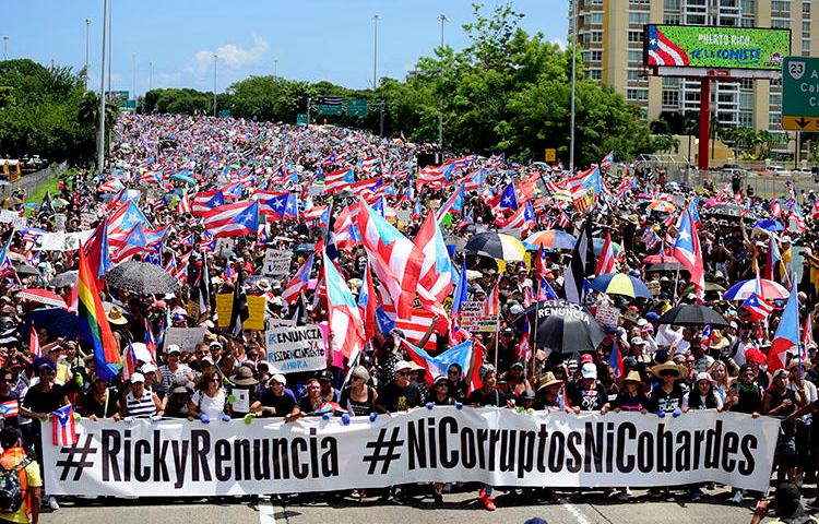 Manifestantes marchan en el Expreso Las Américas exigiendo la renuncia del gobernador Ricardo Roselló en San Juan, Puerto Rico, el 22 de julio de 2019.  Roselló renunció a principios del mes de agosto, pero antes firmó dos leyes que obstruyen el periodismo de investigación en Puerto Rico. (AP Photo/Carlos Giusti)