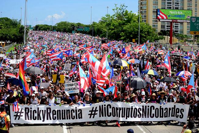 Manifestantes marchan en el Expreso Las Américas exigiendo la renuncia del gobernador Ricardo Roselló en San Juan, Puerto Rico, el 22 de julio de 2019.  Roselló renunció a principios del mes de agosto, pero antes firmó dos leyes que obstruyen el periodismo de investigación en Puerto Rico. (AP Photo/Carlos Giusti)