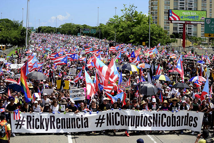 Manifestantes marchan en el Expreso Las Américas exigiendo la renuncia del gobernador Ricardo Roselló en San Juan, Puerto Rico, el 22 de julio de 2019.  Roselló renunció a principios del mes de agosto, pero antes firmó dos leyes que obstruyen el periodismo de investigación en Puerto Rico. (AP Photo/Carlos Giusti)