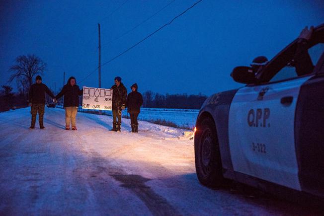 People block train tracks as part of a protest against British Columbia's Coastal GasLink pipeline, in Tyendinaga, Canada, on February 9, 2020. Police recently obstructed and detained journalists covering the protests. (Reuters/Alex Filipe)