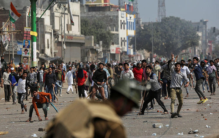 Demonstrators opposing a new citizenship law throw pieces of bricks towards riot police and those supporting the law during a clash in New Delhi, India, on February 24, 2020. (Reuters/Danish Siddiqui)