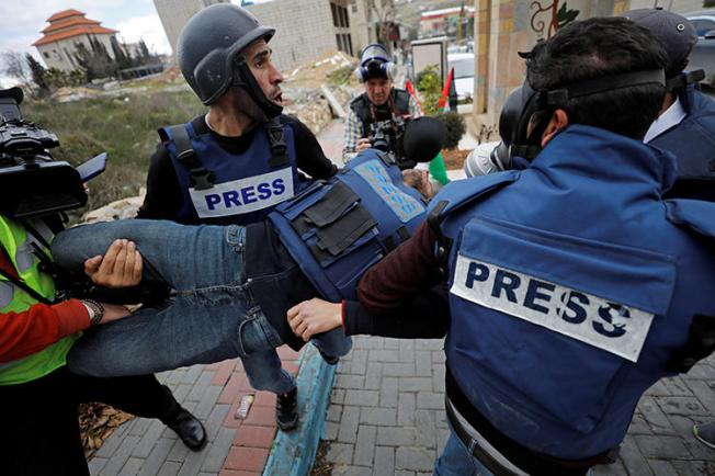 A wounded Palestinian photojournalist is evacuated during a protest in the Israeli-occupied West Bank on February 2, 2020. (Reuters/Mussa Qawasma)