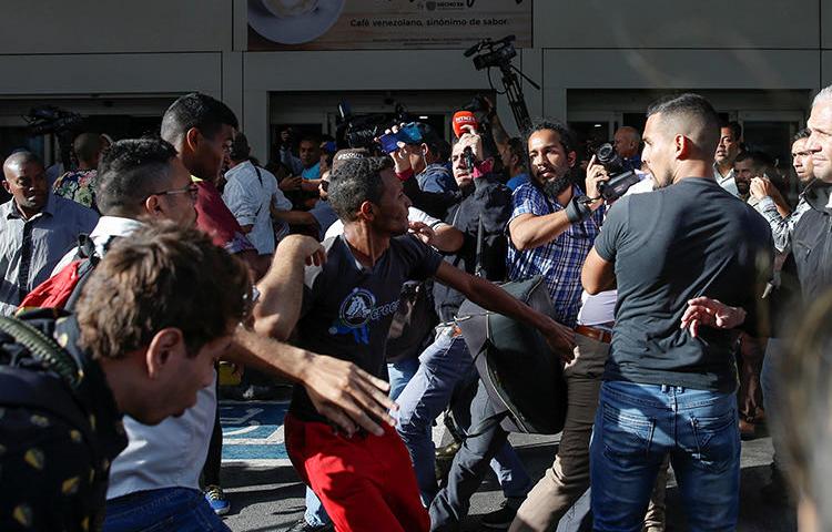 Seguidores del presidente venezolano Nicolás Maduro forcejean con trabajadores de la prensa en el aeropuerto Simón Bolívar en Maiquetía, Venezuela, el 11 de febrero de 2020. (Reuters/Manaure Quintero)