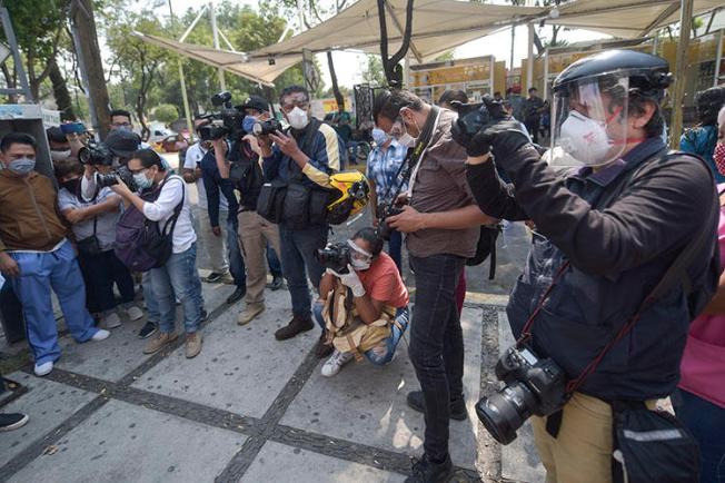 Des journalistes mexicains, portant des équipements de protection individuelle en pleine pandémie de COVID-19, couvrent une manifestation de travailleurs municipaux à l’Hôpital général Balbuena de Mexico, le 16 avril 2020. (AFP/Pedro Pardo)