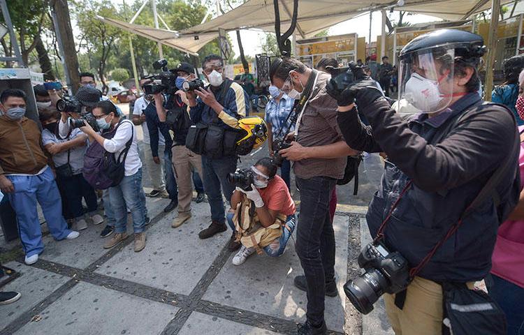 Periodistas mexicanos, con equipo de protección personal a raíz de la pandemia del COVID-19, cubren una protesta de trabajadores administrativos en el Hospital General Balbuena de Ciudad de México el 16 de abril de 2020. (AFP/Pedro Pardo)