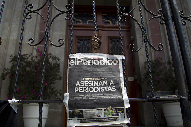 The front page of the newspaper elPeriodico de Guatemala that reads, in Spanish, ‘Journalists killed’ hangs on a gate at the Presidential House during a protest in March 2015 over the killing of journalists Danilo Lopez and Federico Salazar. (AP/Moises Castillo)