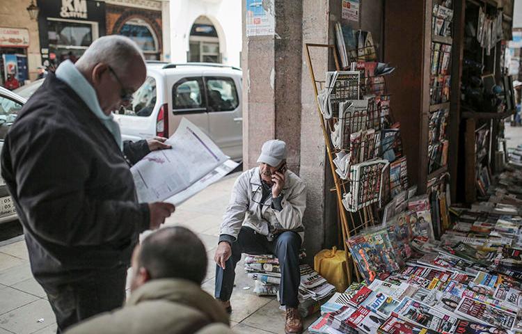 A man reads a newspaper at a stall near the Medina of Rabat, Morocco, on March 16, 2017. Morocco, Yemen, Oman, and Jordan recently ordered newspapers to cease production, citing fears of spreading the COVID-19 virus. (AP/Mosa'ab Elshamy)