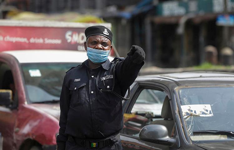 A police officer is seen at a roadblock in Lagos, Nigeria, on March 31, 2020. The Nigerian government recently imposed restrictions on journalists' movement and access to stem the COVID-19 pandemic. (AP/Sunday Alamba)