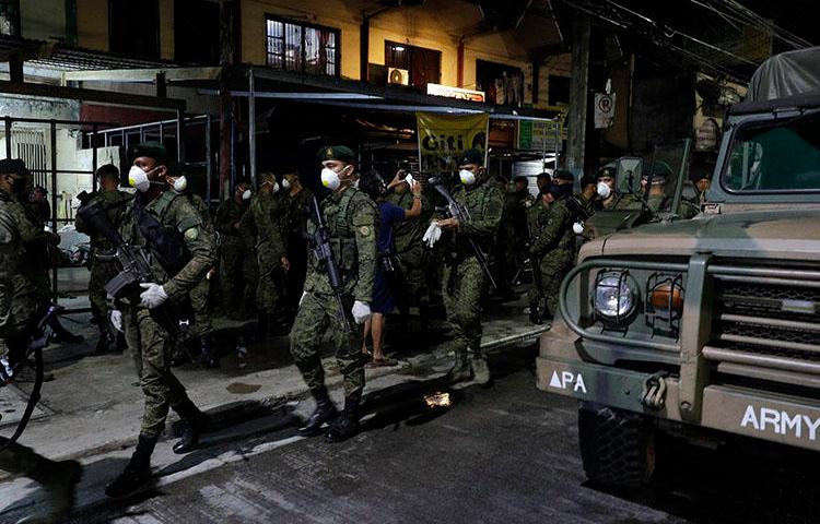 Soldiers are seen in Manila, the Philippines, on March 15, 2020. The country's state of emergency includes a regulation imposing criminal penalties for spreading ‘false news’ about the coronavirus pandemic. (AP/Aaron Favila)