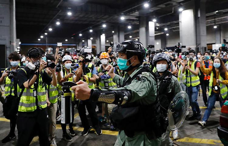 A police officer is seen at a vigil to mourn a student’s death in Hong Kong on March 8, 2020. Police have arrested and attacked journalists covering the vigils. (Reuters/Tyrone Siu)