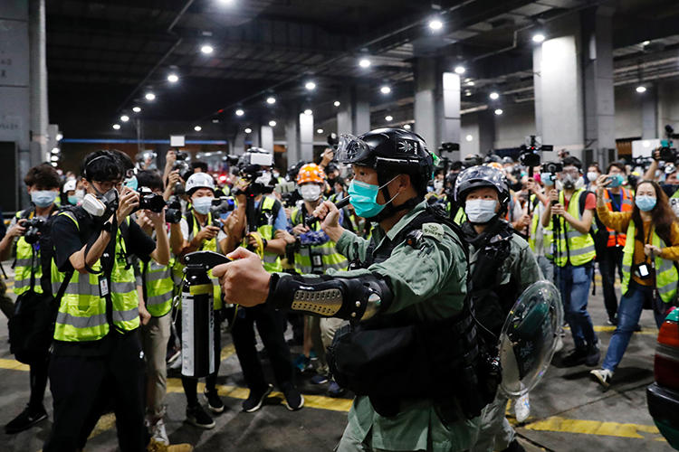 A police officer is seen at a vigil to mourn a student’s death in Hong Kong on March 8, 2020. Police have arrested and attacked journalists covering the vigils. (Reuters/Tyrone Siu)