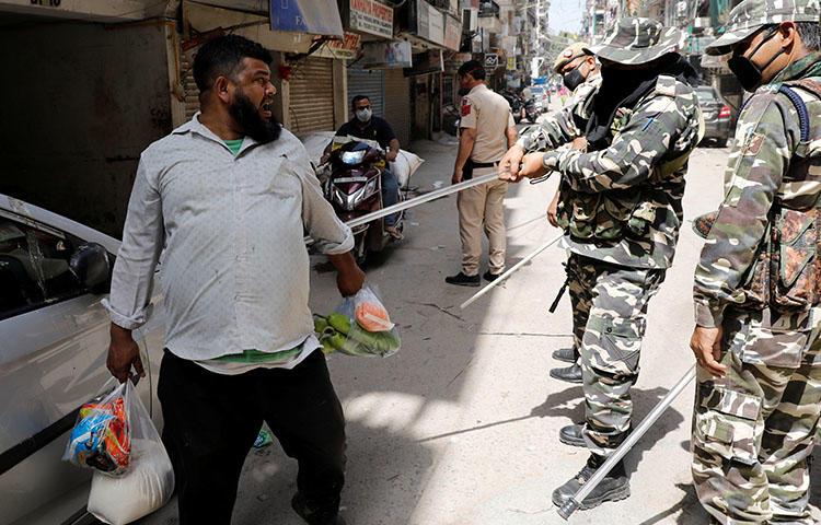 Police officers wield batons against a man for breaking lockdown rules after India ordered a 21-day nationwide lockdown to limit the spreading of coronavirus in New Delhi, India, on March 25, 2020. On March 31, the Indian Supreme Court denied a government request for prior censorship of coronavirus news. (Reuters/Adnan Abidi)