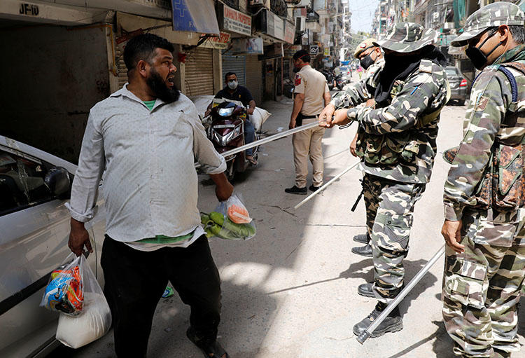 Police officers wield batons against a man for breaking lockdown rules after India ordered a 21-day nationwide lockdown to limit the spreading of coronavirus in New Delhi, India, on March 25, 2020. On March 31, the Indian Supreme Court denied a government request for prior censorship of coronavirus news. (Reuters/Adnan Abidi)