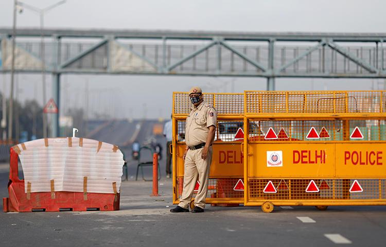 A police officer stands at a barricade in New Delhi, India, on March 23, 2020. Police in New Delhi and Hyderabad recently assaulted journalists for allegedly violating the cities' lockdowns. (Reuters/Adnan Abidi)