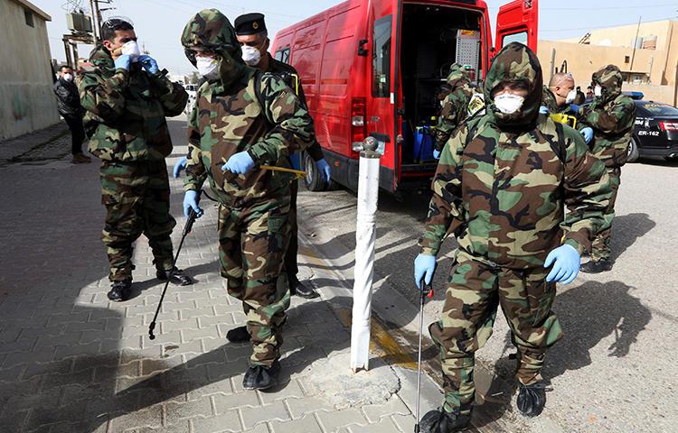 Members of a civil defense team disinfect the homes of people infected with coronavirus in Kirkuk, Iraq, on February 26, 2020. Security officers in Kurkuk recently confiscated the belongings of journalist Azad Shakur for allegedly violating a COVID-19 curfew. (Reuters/Ako Rasheed)