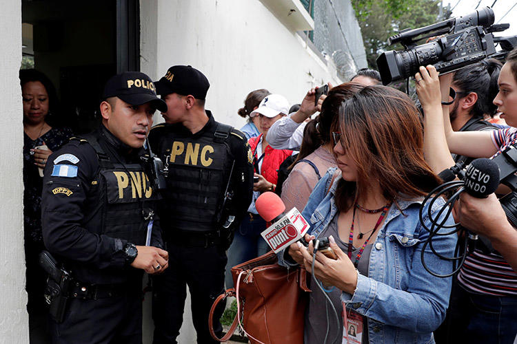 Police and the media are seen outside the Guatemala City offices of the International Commission Against Impunity office (CICIG) in August 2018. The popular U.N.-backed commission helped usher in a decade defined by strong investigative journalism and progress in the fight against Guatemala’s endemic corruption (Reuters/Luis Echeverria)