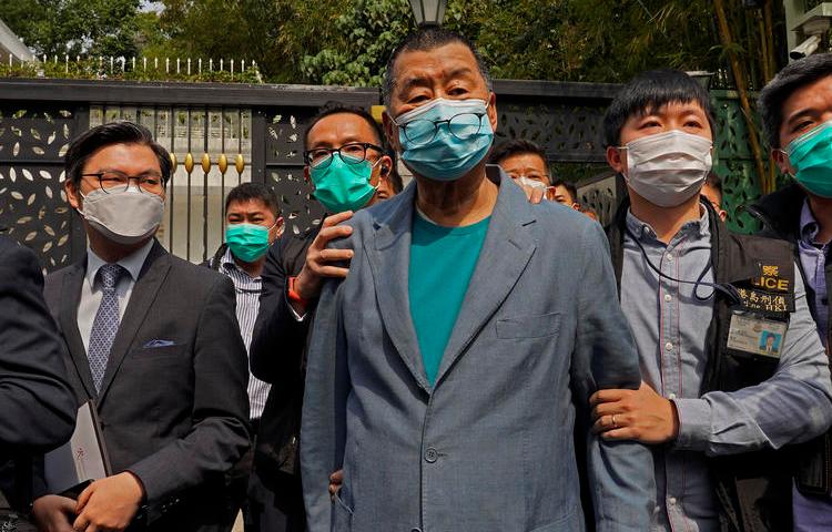 Hong Kong media tycoon Jimmy Lai, center, who founded local newspaper Apple Daily, is arrested by police officers at his home in Hong Kong, Saturday, April 18, 2020. Hong Kong police arrested at least 14 pro-democracy lawmakers and activists on Saturday on charges of joining unlawful protests last year calling for reforms. (AP/Vincent Yu)