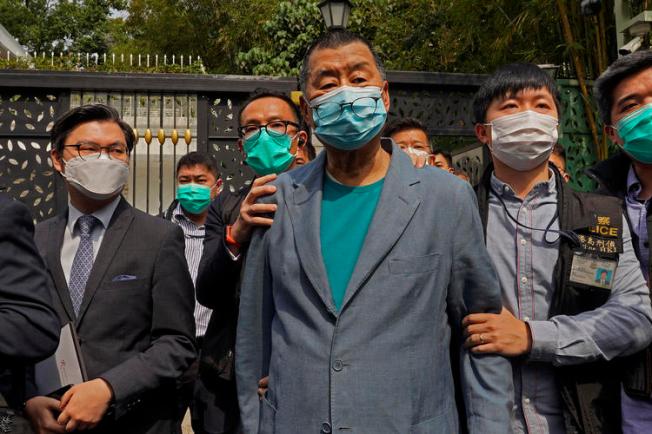 Hong Kong media tycoon Jimmy Lai, center, who founded local newspaper Apple Daily, is arrested by police officers at his home in Hong Kong, Saturday, April 18, 2020. Hong Kong police arrested at least 14 pro-democracy lawmakers and activists on Saturday on charges of joining unlawful protests last year calling for reforms. (AP/Vincent Yu)