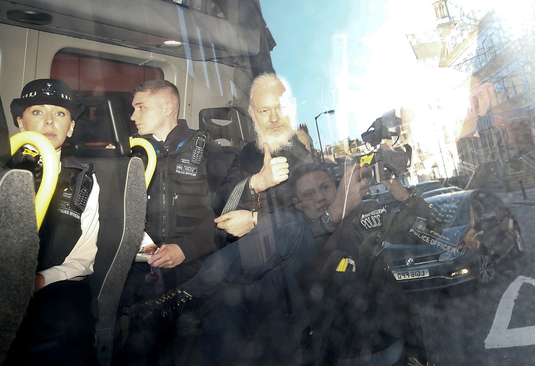WikiLeaks founder Julian Assange gestures as he leaves the Westminster Magistrates’ Court in a police van after he was arrested in London on April 11, 2019. The Trump administration charged Assange under the Espionage Act. (Reuters/Henry Nicholls)