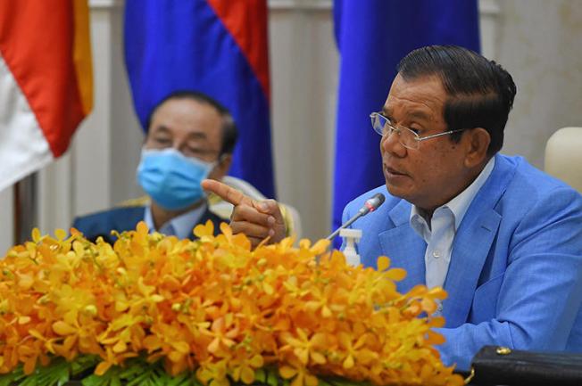 Cambodian Prime Minister Hun Sen (right) is seen during a press conference at the Peace Palace in Phnom Penh on April 7, 2020. Journalist Sovann Rithy was recently detained for publishing quotes from the prime minister. (AFP/Tang Chhin Sothy)