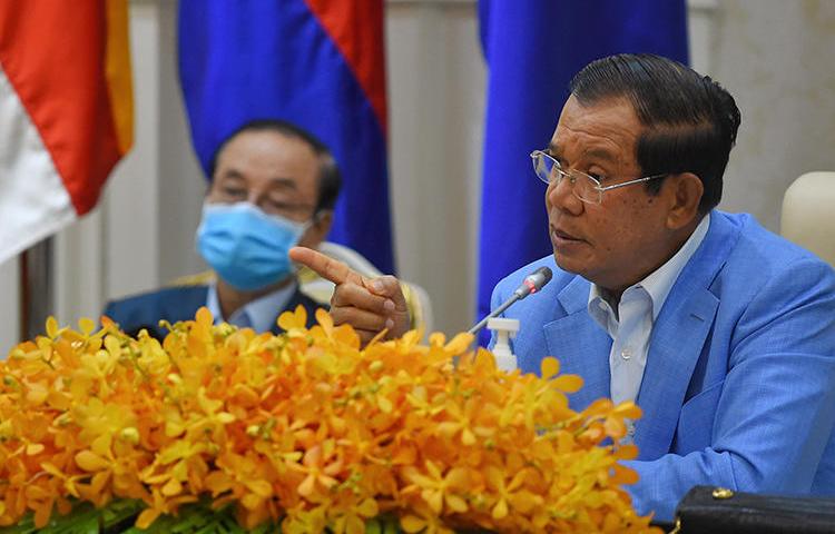 Cambodian Prime Minister Hun Sen (right) is seen during a press conference at the Peace Palace in Phnom Penh on April 7, 2020. Journalist Sovann Rithy was recently detained for publishing quotes from the prime minister. (AFP/Tang Chhin Sothy)