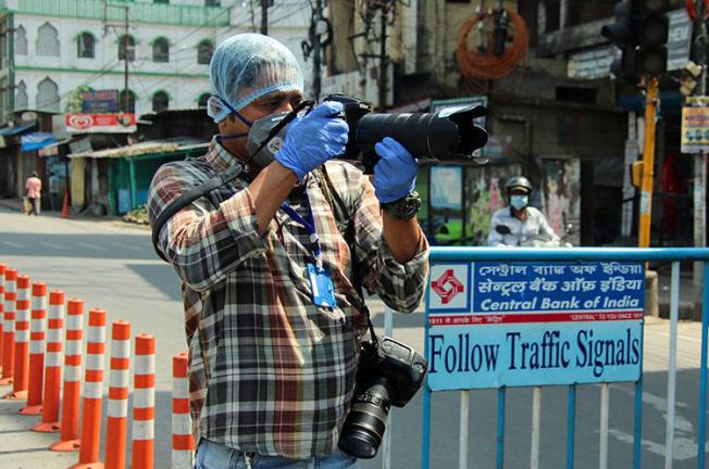 AFP photographer Diptendu Dutta works during a government-imposed nationwide lockdown as a preventive measure against the spread of COVID-19 in Siliguri, India, on April 10, 2020. Freelance journalists have faced risks to their lives and livelihoods amid the COVID-19 pandemic. (AFP)