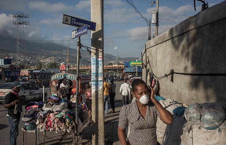 A woman walks in downtown Port au Prince, Haiti, on March 26, 2020. Eight journalists were recently attacked while covering the coronavirus pandemic in Port au Prince. (AFP/Pierre Michel Jean)