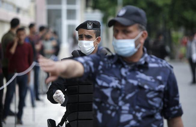 Police are seen in Gaza City on March 31, 2020. Police in Gaza recently arrested Palestinian cartoonist Ismael el-Bozom. (AFP/Mohammed Abed)