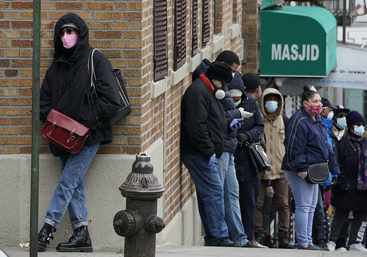 People wait in line for a coronavirus test at a new walk-in testing sites that opened in the parking lot of NYC Health + Hospitals/Gotham Health Morrisania in the Bronx section of New York on April 20, 2020. Photographers in New York and around the U.S. have had to navigate a new reality under COVID-19. (AFP/Timothy A. Clary)