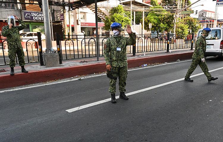 Police officers are seen in Manila, the Philippines, on March 25, 2020. National police recently filed a criminal complaint on behalf of Cavite City authorities against two journalists for spreading 'false information' about COVID-19. (AFP/Ted Aljibe)