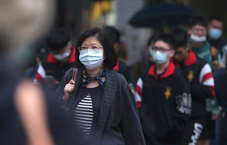 People walk on a street in Taipei, Taiwan, on March 30, 2020. CPJ recently spoke with journalist Brian Hioe on covering COVID-19 in Taiwan. (AP/Chiang Ying-ying)